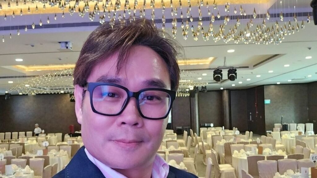 Barry Chou with a microphone in the banquet hall before a private dinner